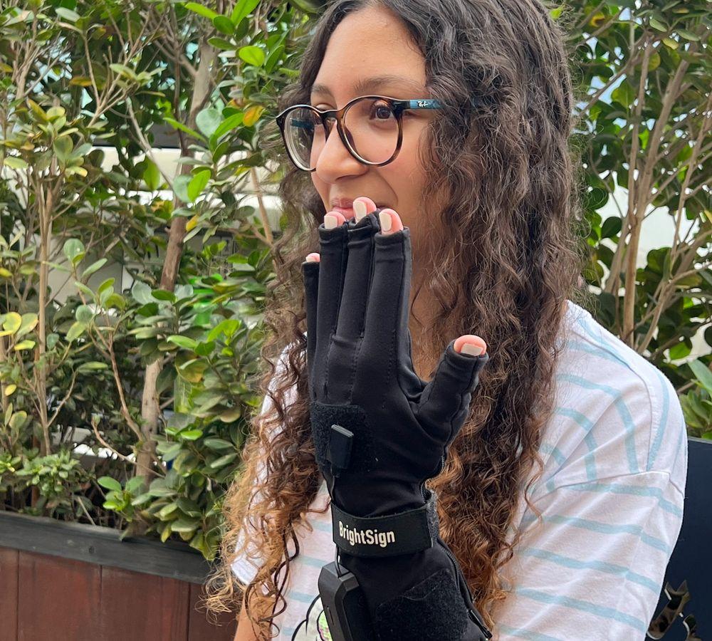 Girl holding up a BrightSign glove on her hand